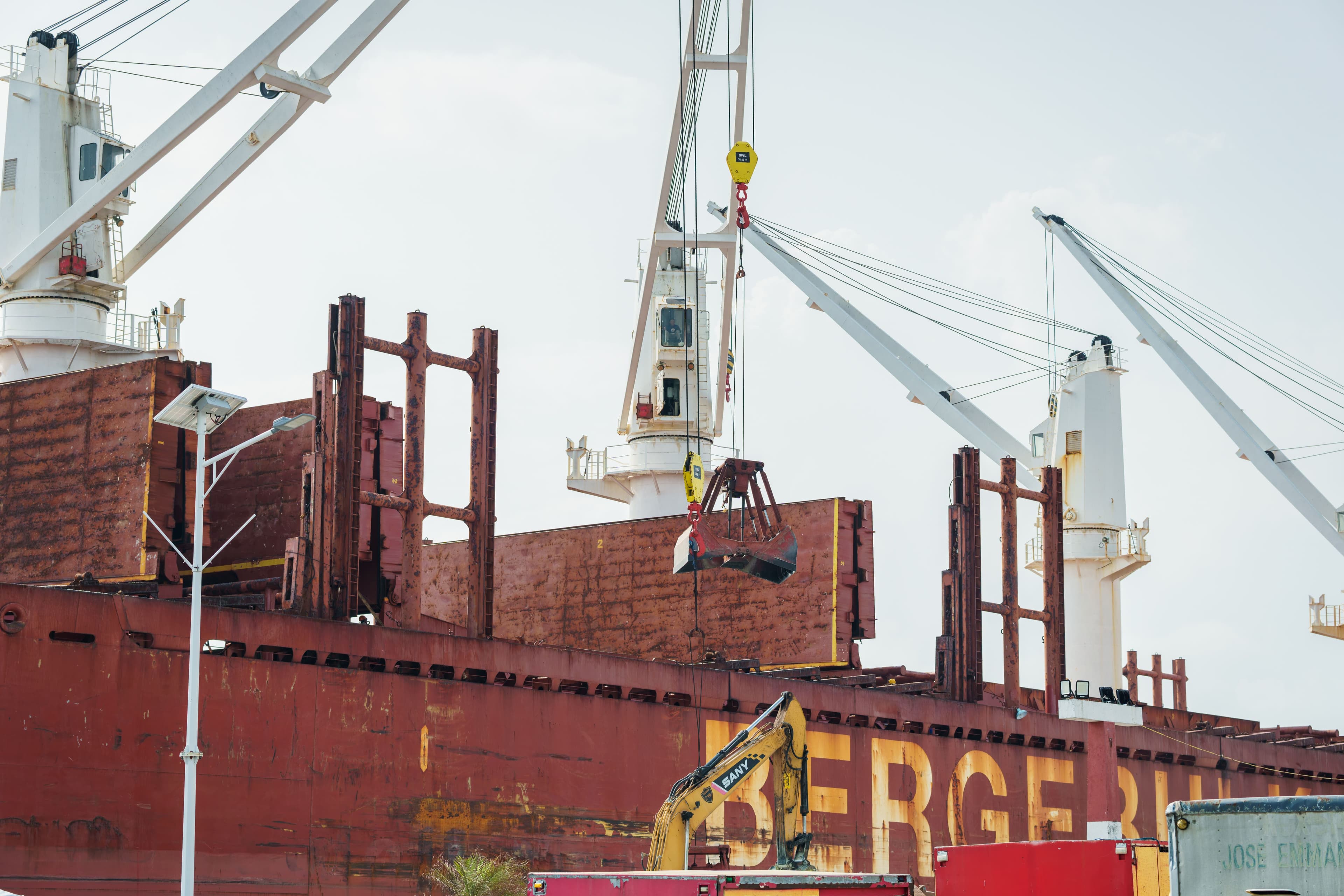 Ship cranes and loading gear working cargo on a vessel's deck